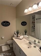 Bathroom featuring a shower with curtain, toilet,
