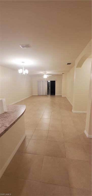Empty room featuring baseboards, light tile patter