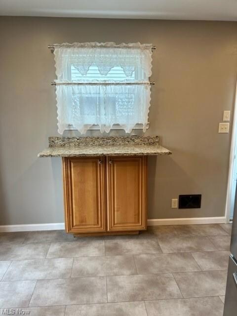 Kitchen with light stone countertops and light tile floors