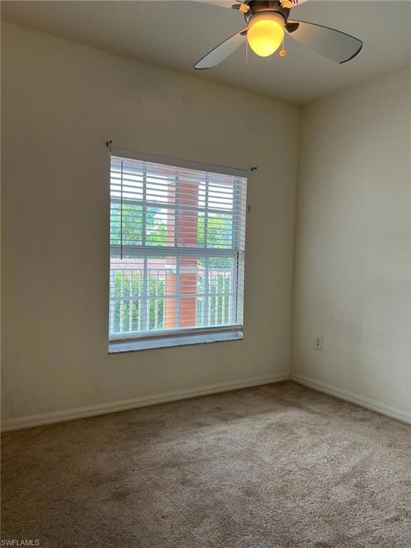 Carpeted empty room featuring ceiling fan