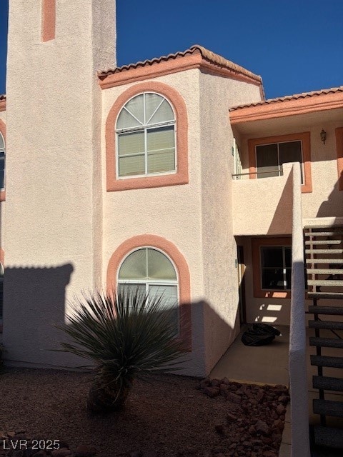 View of front of home featuring stucco siding and a tiled roof