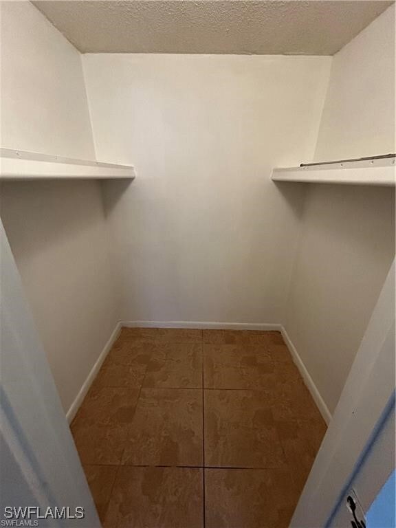 Walk in closet featuring dark tile patterned floor