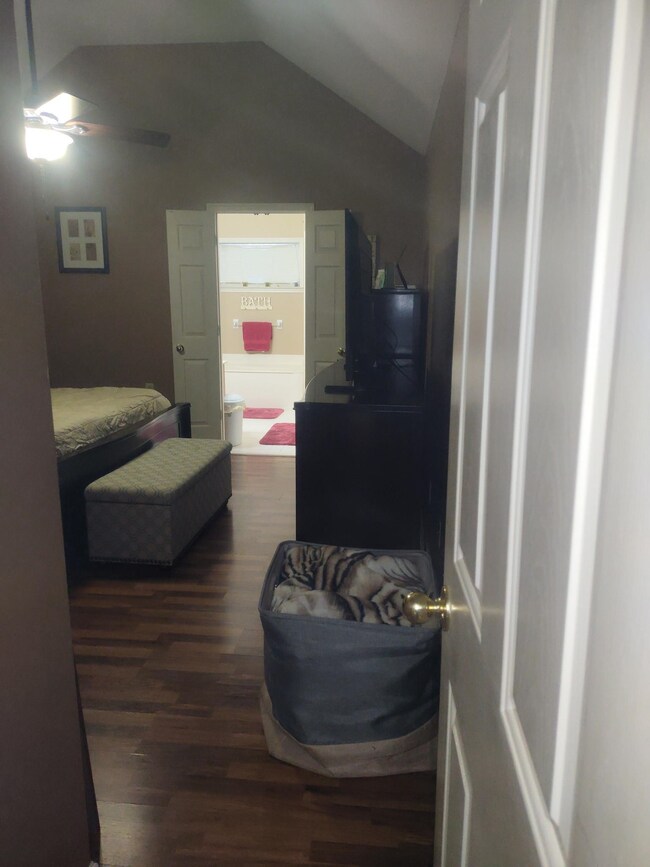 Bedroom with ceiling fan, dark hardwood / wood-sty