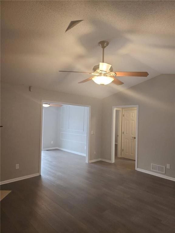Unfurnished room featuring lofted ceiling, dark wood-style floors, a ceiling fan, and a textured ceiling