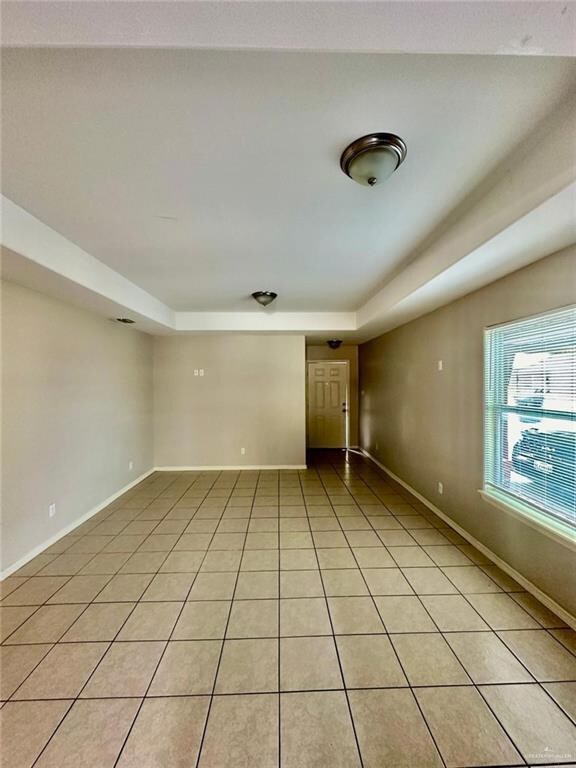 Tiled empty room with a raised ceiling
