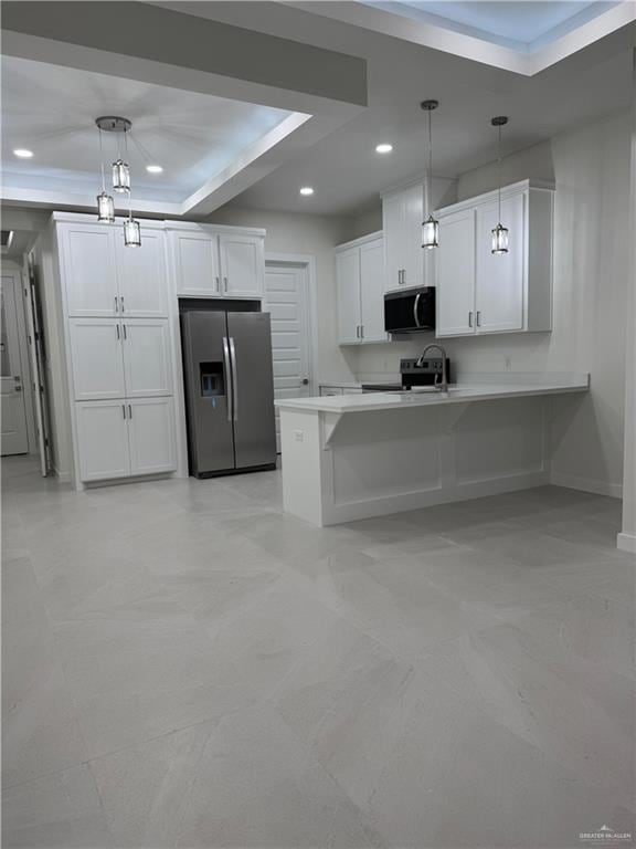 Kitchen featuring a kitchen breakfast bar, white cabinets, stainless steel appliances, a peninsula, and recessed lighting