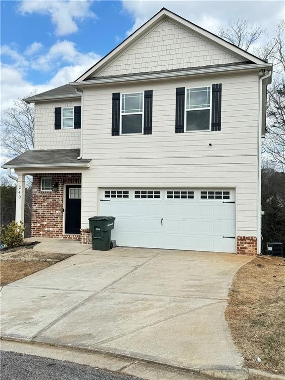 Traditional home with brick siding, a garage, and driveway