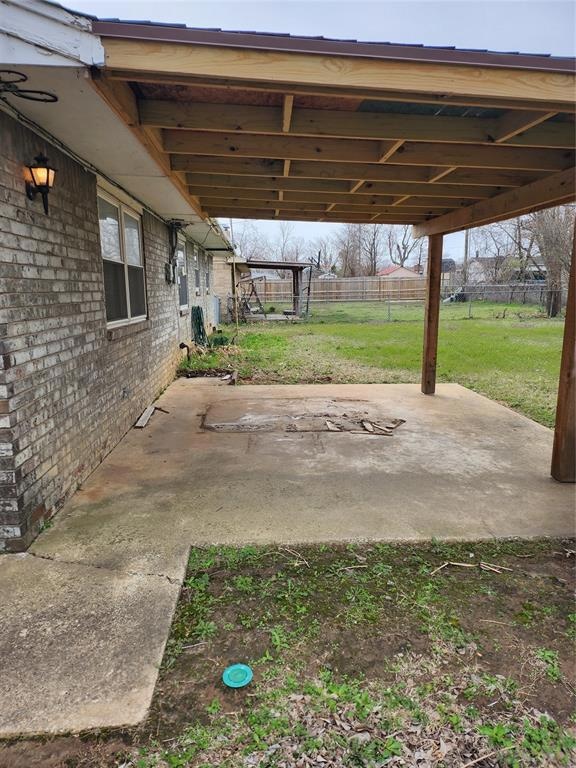 View of patio featuring a carport and fence