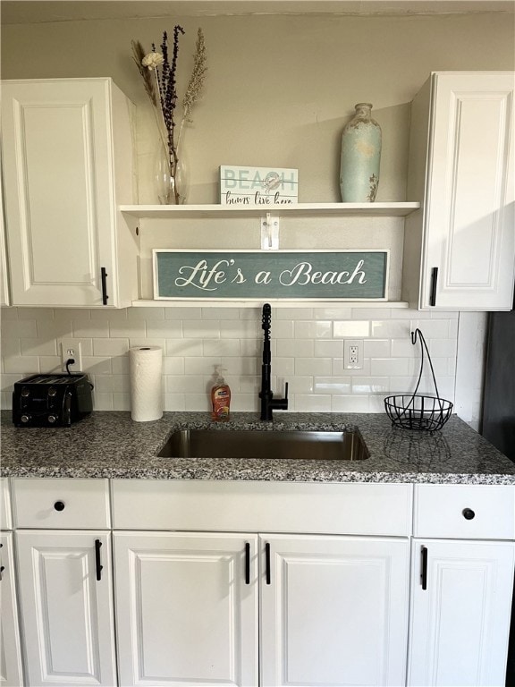 Bar area featuring tasteful backsplash, open shelves, and white cabinetry