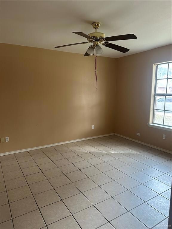 Empty room featuring baseboards and a ceiling fan