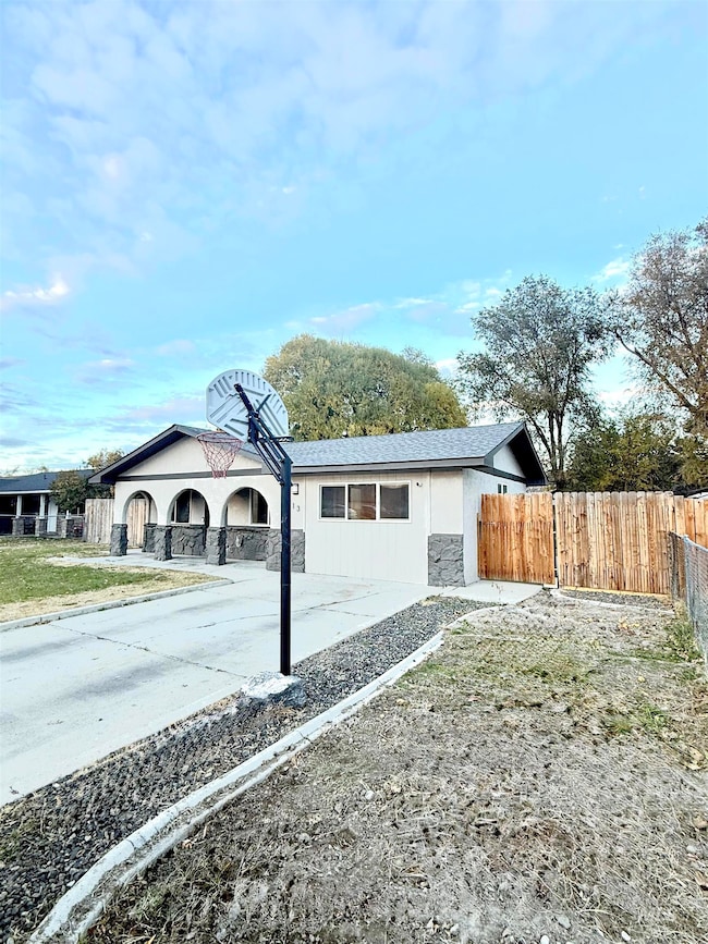 View of property exterior with stone siding and driveway
