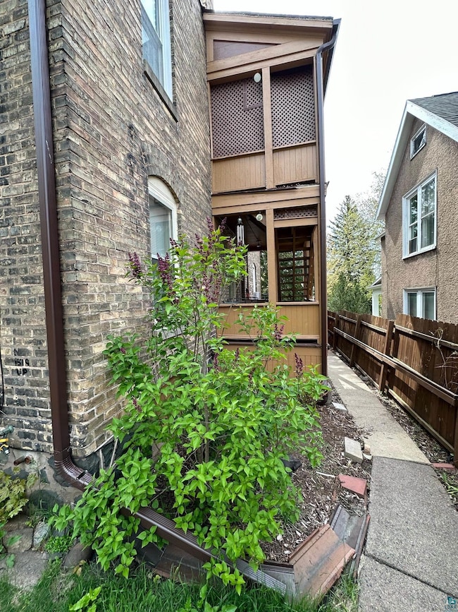 View of property exterior featuring a vegetable garden and brick siding