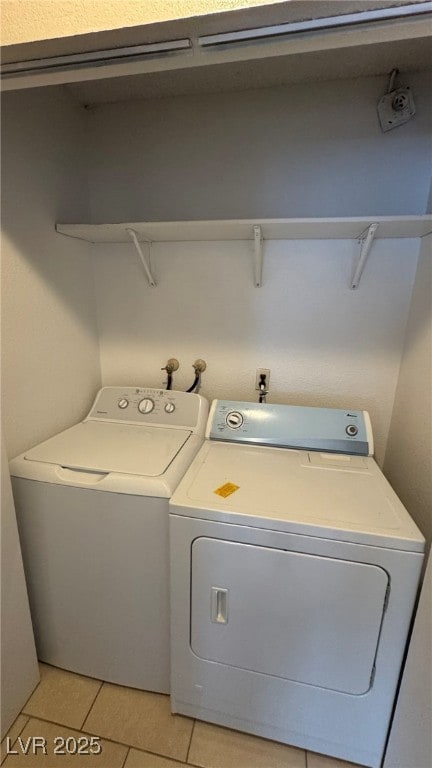 Washroom featuring light tile patterned flooring and washing machine and clothes dryer