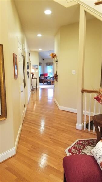LONG HALL WAY OFF OF FOYER LEADS TO HALF BATH AND 