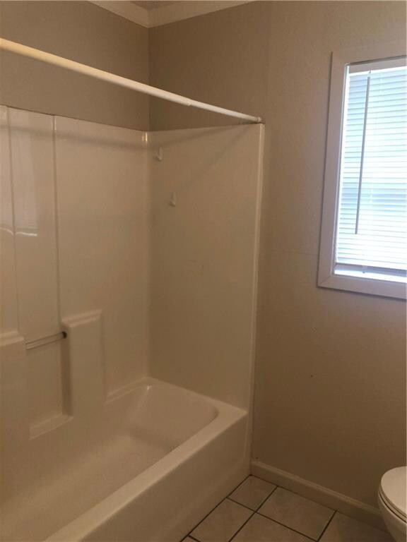 Bathroom with tile patterned floors, crown molding, and shower / bath combination