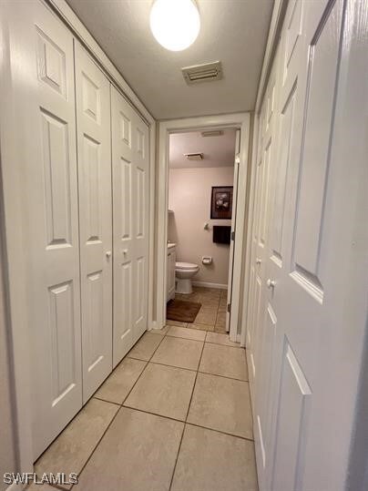 Hall featuring light tile patterned flooring and v