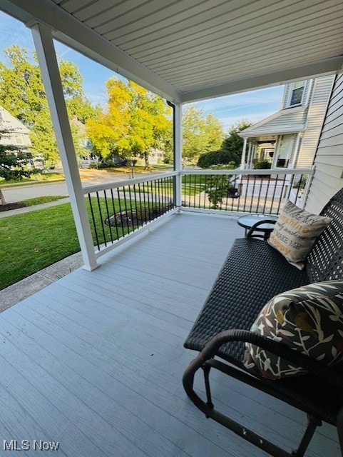 Lovely front porch has newer flooring and railings