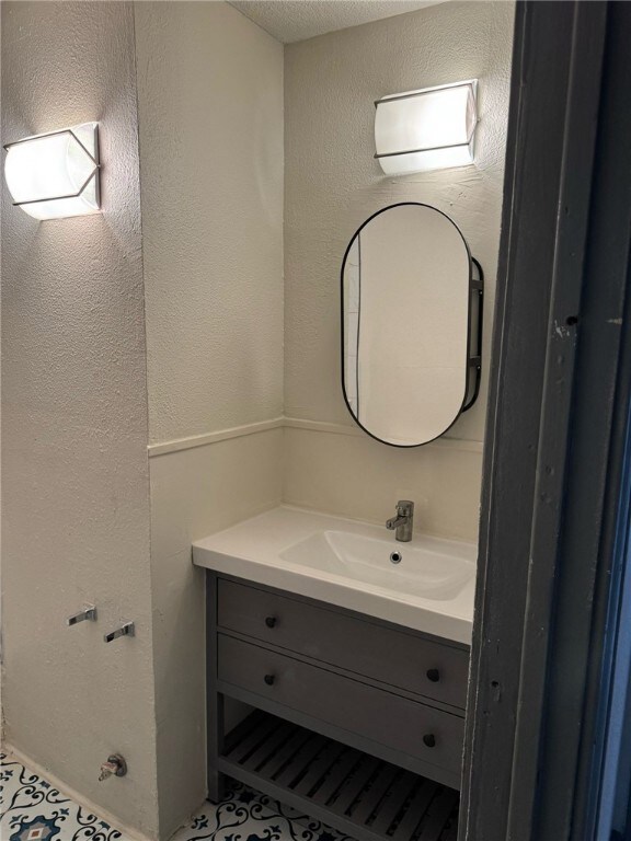 Bathroom featuring vanity and a textured ceiling