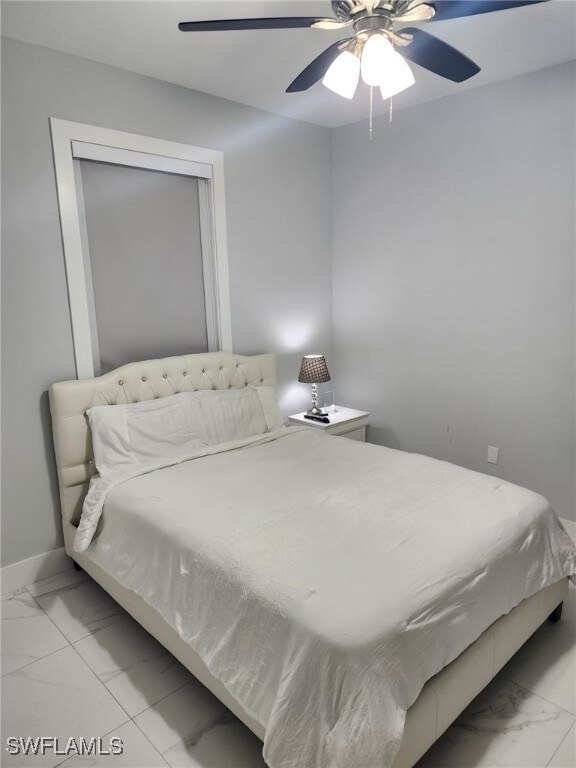 Bedroom featuring marble look tiles and ceiling fa