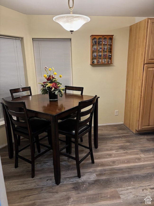 Dining area featuring dark wood finished floors and baseboards