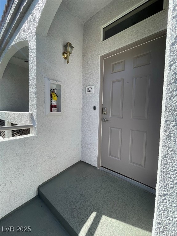 Property entrance featuring stucco siding