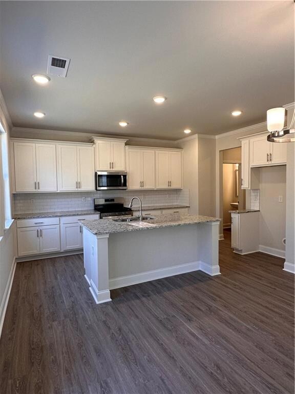 Kitchen features a tile backsplash, stainless appliances, and granite countertops.