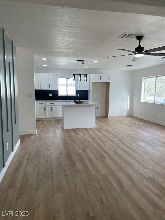 Kitchen featuring white cabinetry, a kitchen islan