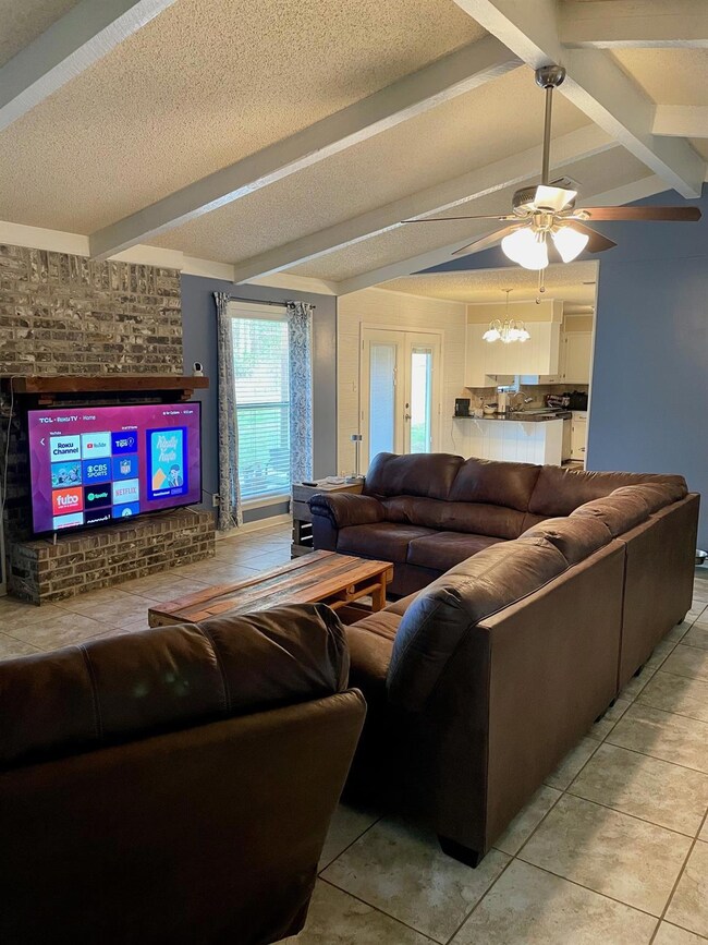 Living area featuring ceiling fan with notable cha