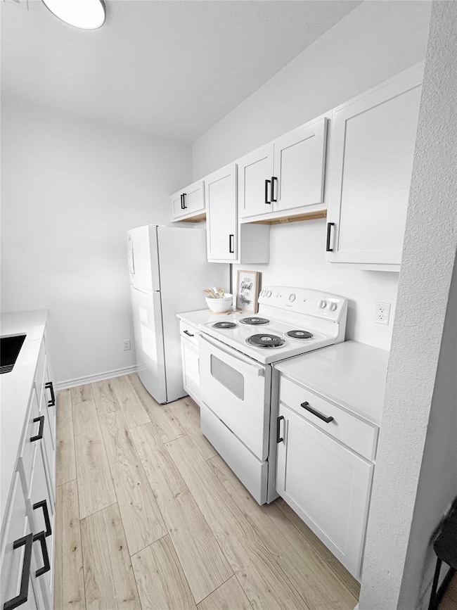 Kitchen featuring white appliances, white cabinet