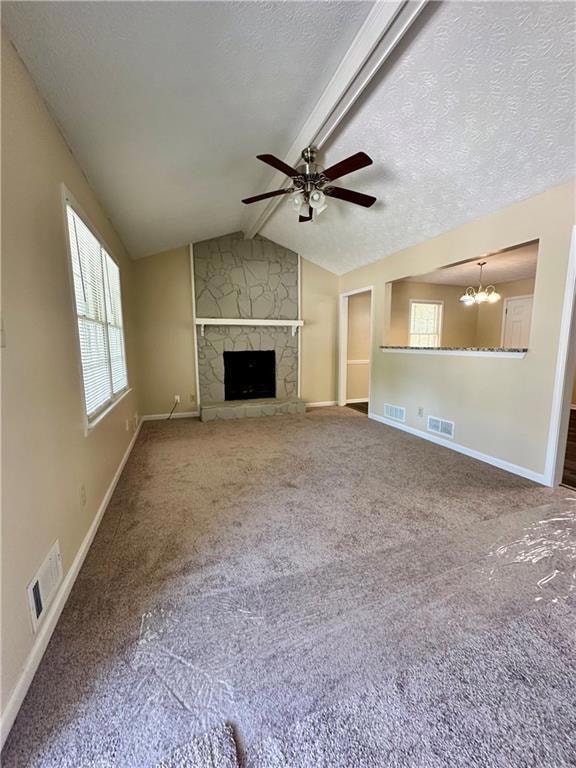 Unfurnished living room with carpet floors, a fireplace, ceiling fan, a textured ceiling, and a chandelier