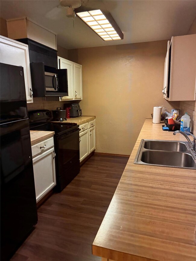 Kitchen with ceiling fan, white cabinets, sink, da
