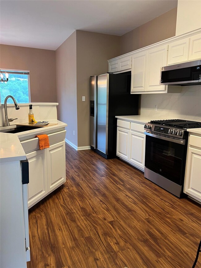 Kitchen featuring dark wood-type flooring, light 