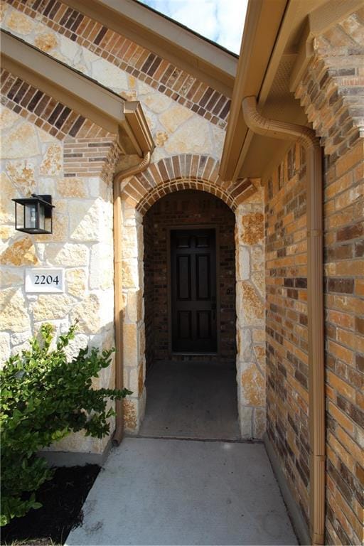 View of exterior entry featuring stone siding and