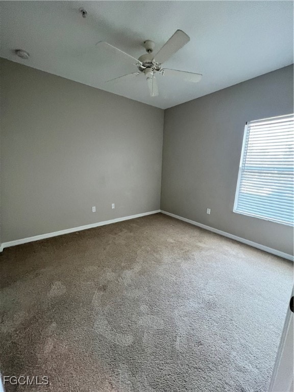 Spare room featuring a ceiling fan and carpet