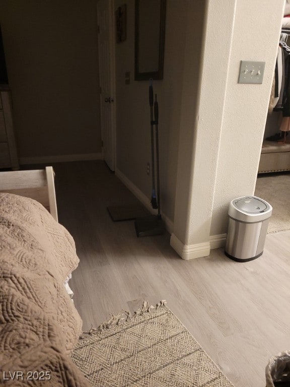 Bedroom featuring wood finished floors and baseboa