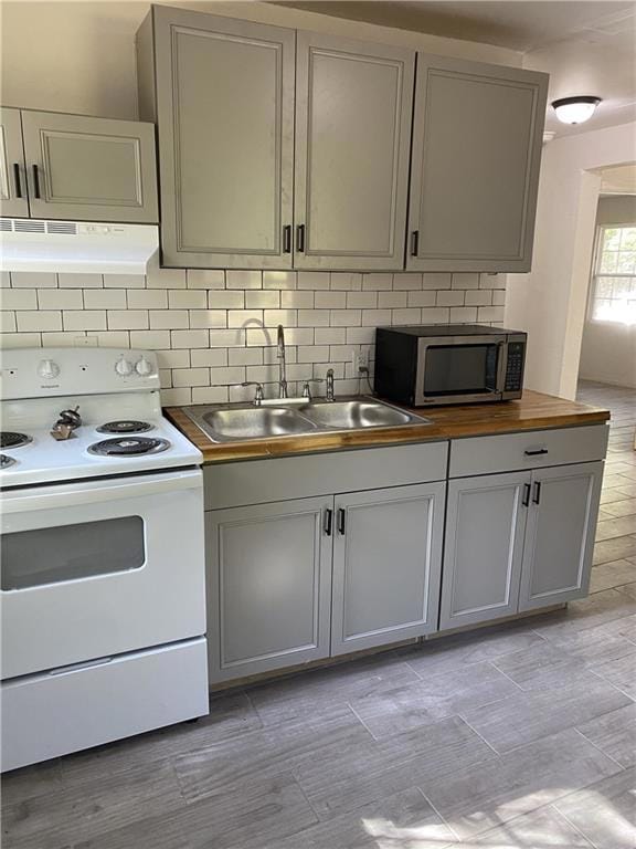 Kitchen featuring white electric range oven, stain