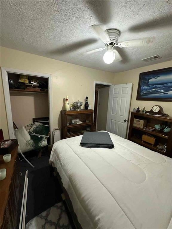 Bedroom featuring a textured ceiling, a ceiling fan, and a closet