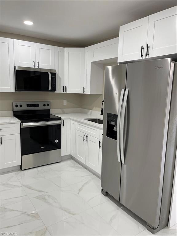 Kitchen with stove, sink, stainless steel refriger