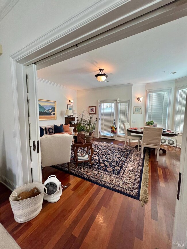 Unit 102 – This view looks back toward the entry door, with the dining room to the right and a sitting area to the left, as currently arranged by the tenant.