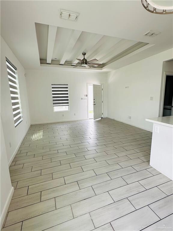 Empty room featuring a wealth of natural light, a ceiling fan, and visible vents