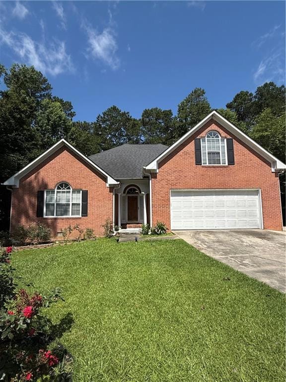 Ranch-style home featuring concrete driveway, brick siding, a front yard, and a garage