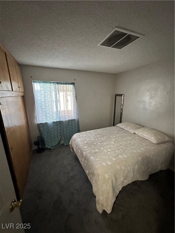 Bedroom featuring carpet and a textured ceiling