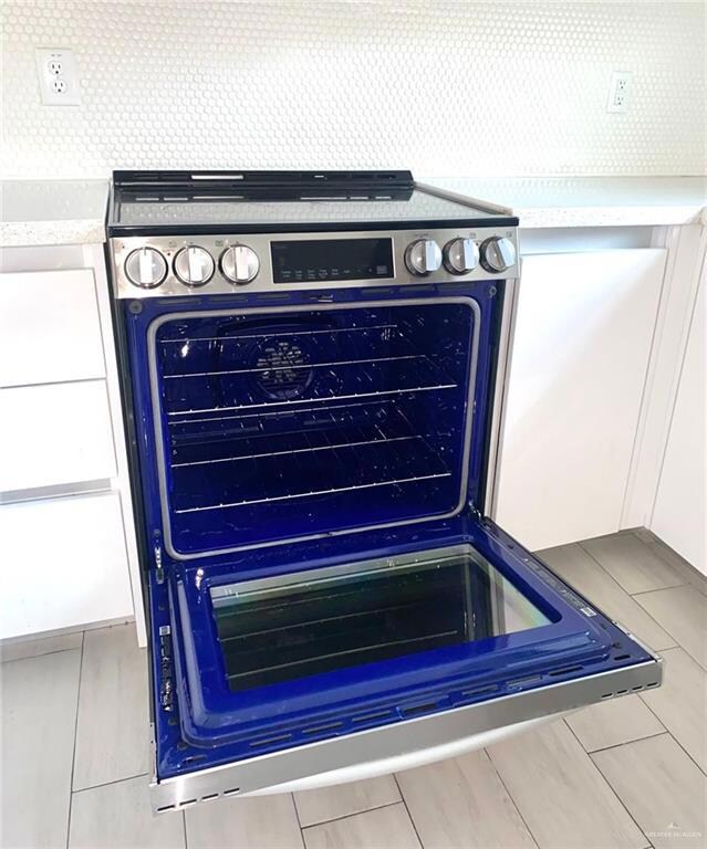 Detailed view of tasteful backsplash and stainless steel range with electric cooktop