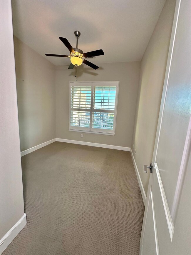 Unfurnished room with ceiling fan and carpet