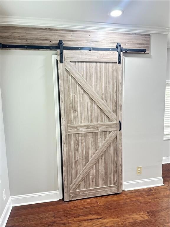 Room details with a barn door and hardwood / wood-