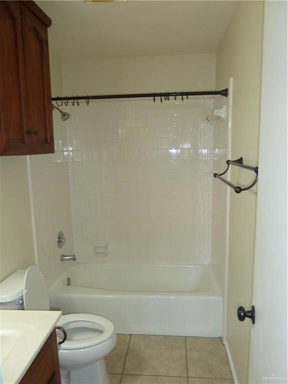 Full bathroom featuring tile floors, vanity, bathing tub / shower combination, and toilet
