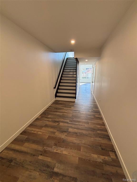 Hallway featuring stairway, dark wood-style floors, and recessed lighting