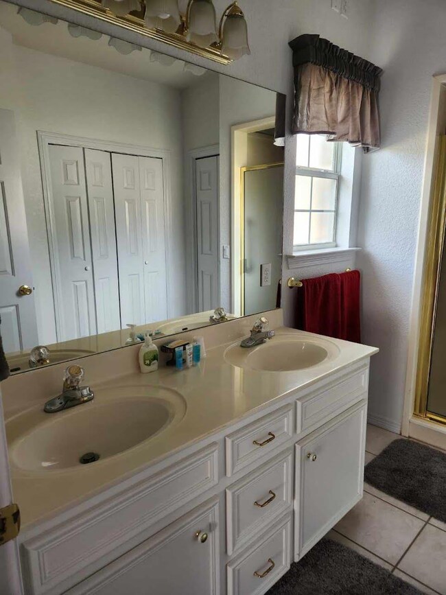Full bath with a closet, a stall shower, double v