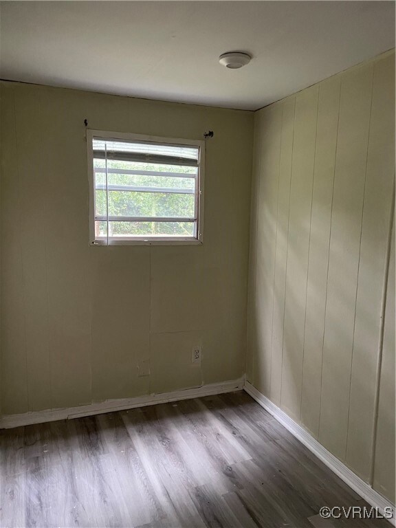 Unfurnished room with wood finished floors and bas