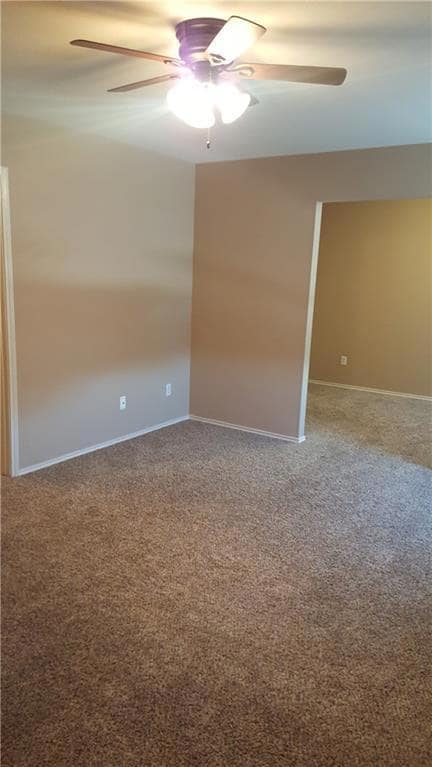 Spare room with ceiling fan, carpet flooring, and
